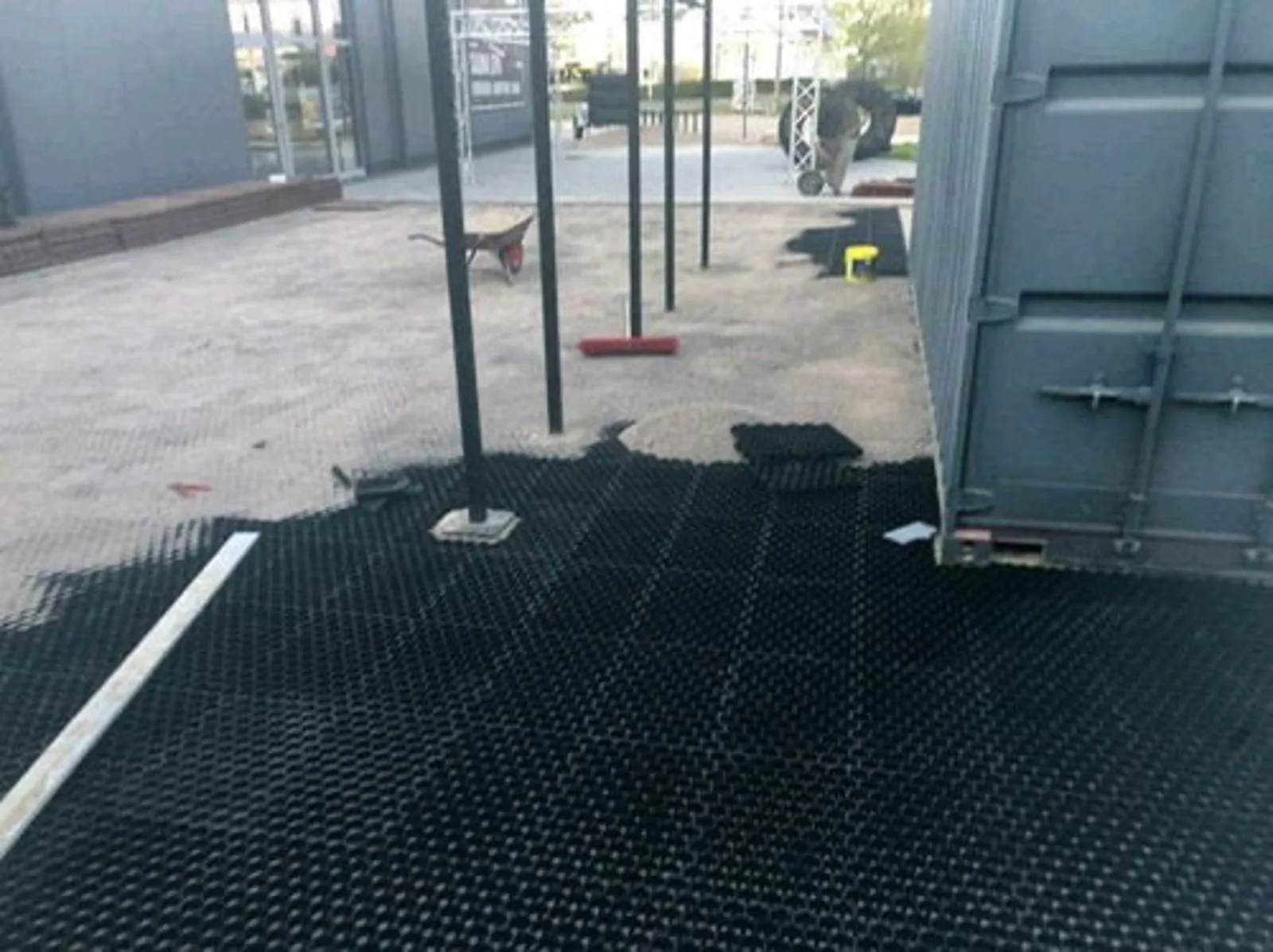 Mit Kunststoffgitter befestigte Hofzufahrt neben parkenden Fahrzeugen