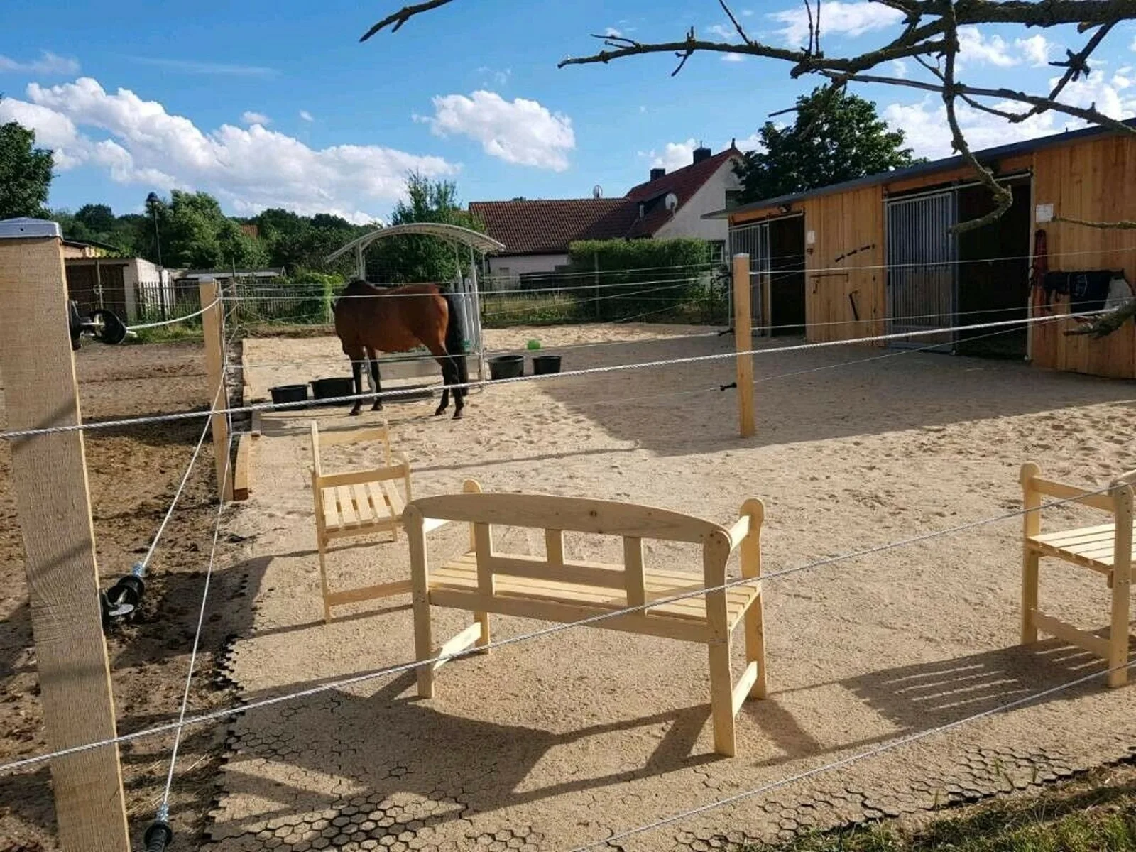 Person verlegt schwarze Paddockplatten auf vorbereiteter Fläche